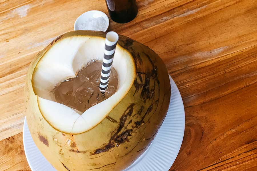 Coconut drink with ice and straw.