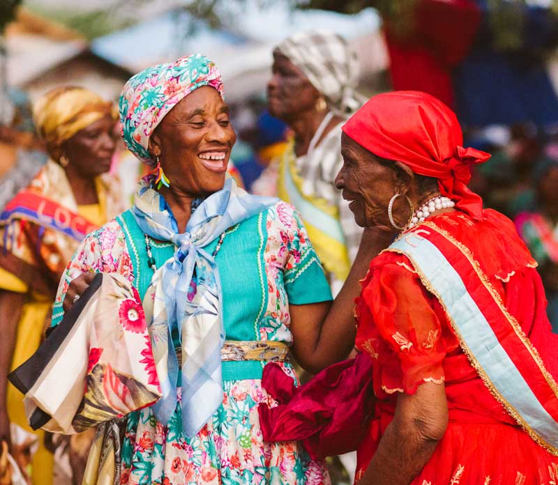 Four laughing Haitian women in traditional costume