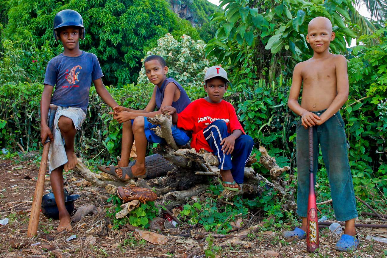Dominican children with baseball equipment.