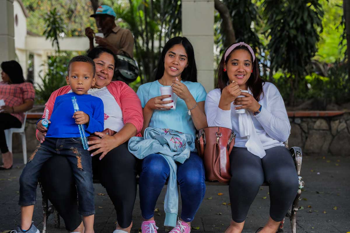 Dominican people eating ice cream on bench.