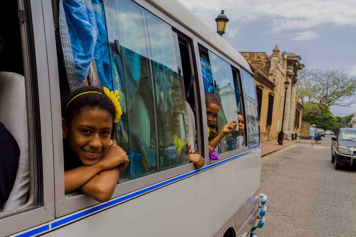 Children in Santo Domingo laughing in bus windows.