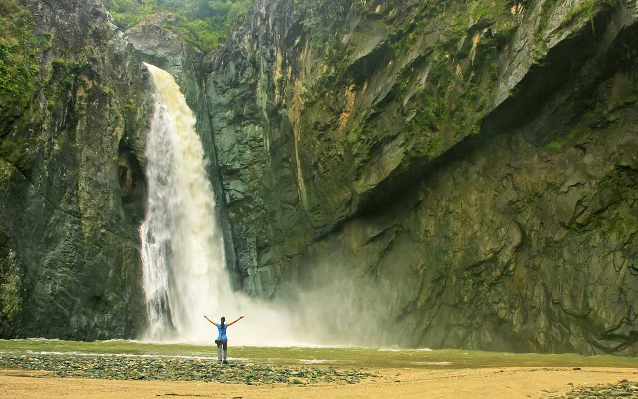 Woman in front of Jimenoa 1 waterfall.