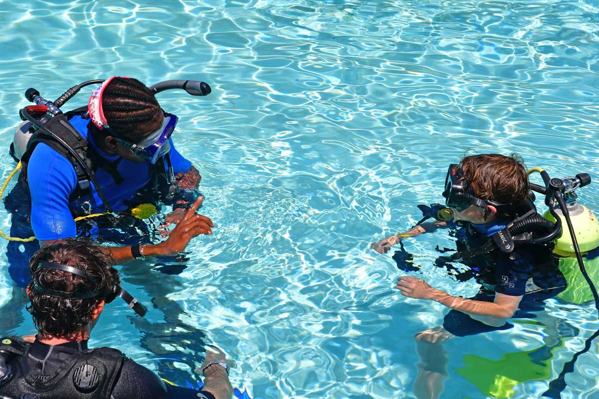 Scuba divers receiving instructions from professional.