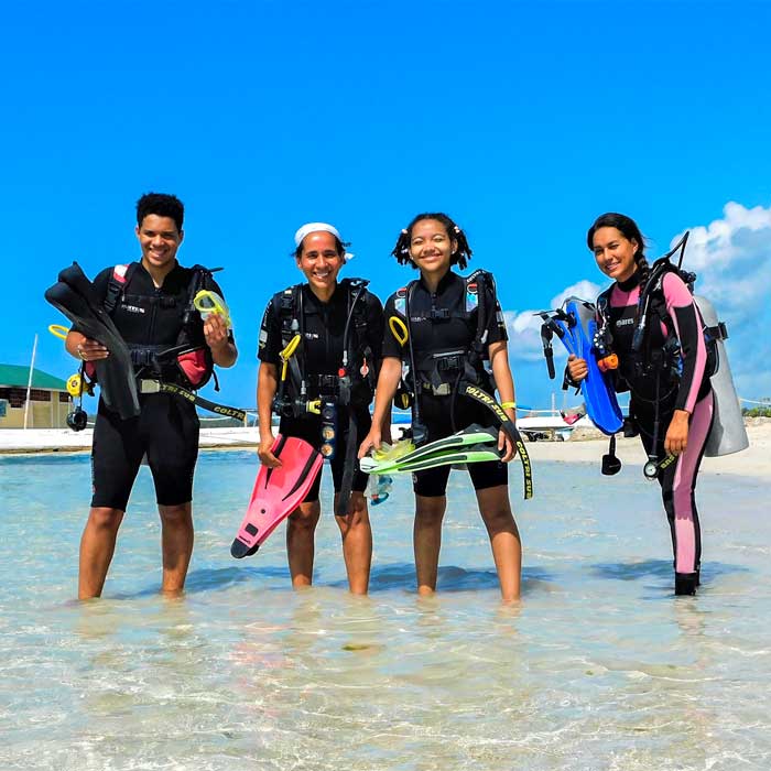 Four people in Diving gear.